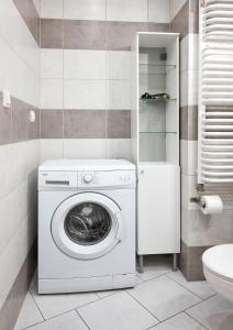 - un lave-linge dans la salle de bains pourvue de toilettes dans l'établissement Osiedle Zwycięstwa Standard Apartment, à Poznań