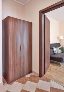 - une chambre avec un grand placard en bois et un lit dans l'établissement Osiedle Zwycięstwa Standard Apartment, à Poznań