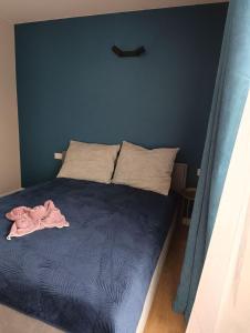 1 cama en un dormitorio con una pared azul en BMH Apartments Rzeszów, en Rzeszów