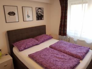 a bed with purple pillows on it in a bedroom at Zagreb apartment in Zagreb