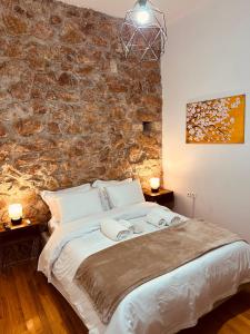 sypialnia z dużym łóżkiem i kamienną ścianą w obiekcie CONTEMPORARY APARTMENT 200M FROM ACROPOLIS 100Mbps NETFLIX w Atenach