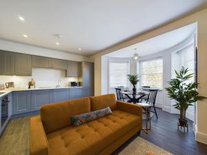 ein Wohnzimmer mit einem Sofa und eine Küche mit einem Tisch in der Unterkunft SunningEnd W King SBed EV Parking in Cheltenham