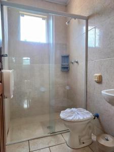 a bathroom with a shower with a toilet and a sink at JSA Hotel in Siqueira Campos