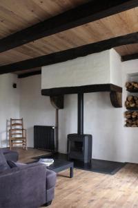 - un salon avec une cheminée et un canapé dans l'établissement VESTIGES, ancien corps de ferme rénové selon l'esprit wabi-sabi, à Saint-Antonin