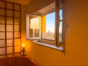 - une fenêtre dans une chambre avec vue sur la ville dans l'établissement Appartamento nel centro storico di Tuscania - Il Moro, à Tuscania