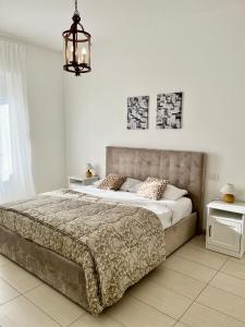 a bedroom with a large bed and a chandelier at Marco Polo Apartment in Milan