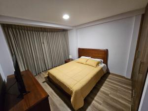 a bedroom with a bed and a flat screen tv at New Dawn Rio in Riobamba