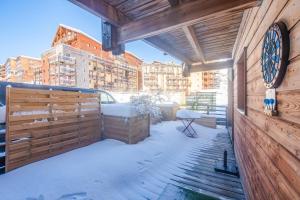 a balcony with a wooden wall with a clock on it at Oricigones - Station accessible à pieds in Orcières