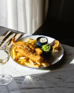 um prato de comida com peixe e batatas fritas numa mesa em Leonardo Hotel Manchester Piccadilly em Manchester