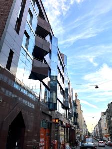 a tall building with glass windows on a city street at Downtown Suite in Helsinki