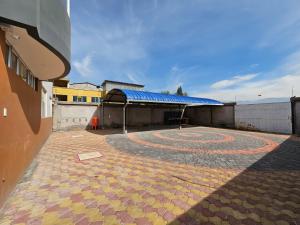 a building with a large patio with a blue roof at New Dawn Rio in Riobamba