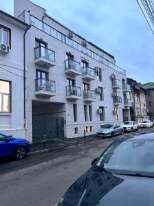a white building with cars parked in front of it at Elegance in Bucharest