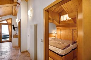 sypialnia z łóżkiem w pokoju z drewnianymi ścianami w obiekcie Appartamento Piz Saliente w Livigno