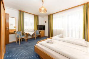 シュラートミンクにあるAppartement Wartinger by Schladming-Appartementsのベッド2台とテーブルが備わるホテルルームです。