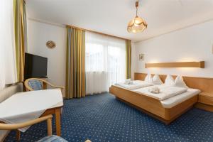 シュラートミンクにあるAppartement Wartinger by Schladming-Appartementsのベッドとデスクが備わるホテルルームです。