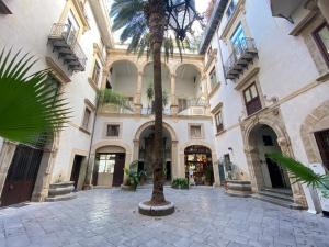 um pátio com uma palmeira num edifício em Balat City by Holiday World em Palermo