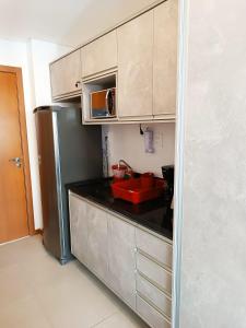 a kitchen with a refrigerator and a red sink at Barra Caravela Studio in Salvador