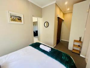 Un dormitorio con una cama con una manta verde. en 31 on Park, en Grahamstown