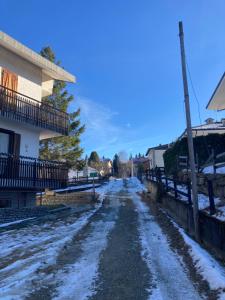 een met sneeuw bedekte straat voor een huis bij All’angolo delle alpi in Montoso