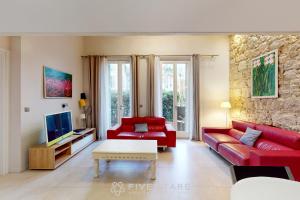a living room with a red couch and a tv at Loft Gambetta 33 Fshh in Nice