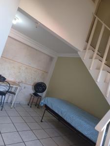 a room with a bed and a table and chairs at Kitnet Praia Jacaraipe in Serra