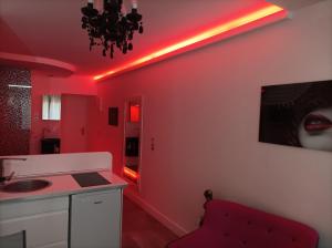 een rode keuken met een wastafel en een rood plafond bij Village Naturiste Studio Luxe in Cap d'Agde
