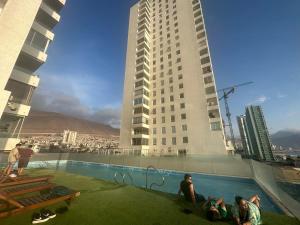 a group of people sitting in a pool on top of a building at Departamento Playa Brava 3D 2B in Iquique