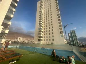 een groep mensen in een zwembad bovenop een gebouw bij Departamento Playa Brava 3D 2B in Iquique