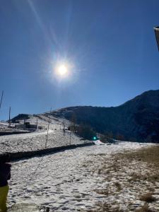 a person standing on top of a snow covered hill at All’angolo delle alpi in Montoso