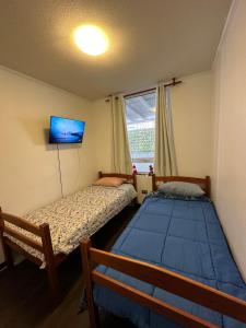 twee bedden in een kleine kamer met een raam bij Departamento Playa Brava 3D 2B in Iquique +12 foto's
