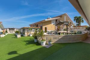 a house with a yard with green grass at Re Sole Resort&Spa in Grottaglie