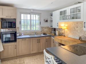 a kitchen with white cabinets and a counter top at Mas du Murier in Correns