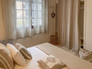 a bedroom with a bed with pillows and a window at Mas du Murier in Correns