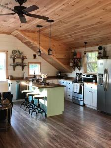 une cuisine avec un îlot et des tabourets de bar dans l'établissement Barndominium with lake view, close to Nashville!, à Lebanon