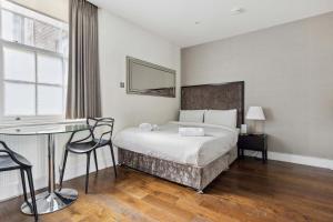 a hotel room with a bed and a desk and a window at Golden Square in London