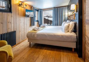 een slaapkamer met een bed in een kamer met een raam bij Chalet Carte Blanche Thovex in Val dʼIsère