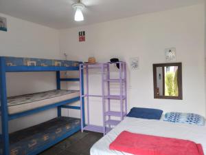 Pokój z 2 łóżkami piętrowymi i lustrem w obiekcie Farah Suítes e Passeio de barco w mieście Boiçucanga