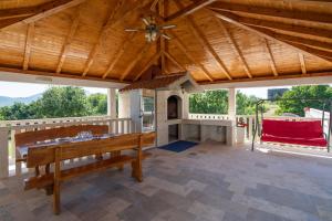 a large patio with a table and a wooden ceiling at Villa Paradiso in Blato na Cetini