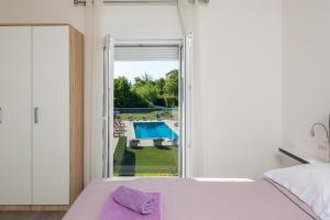 a bedroom with a bed and a window with a pool at Villa Paradiso in Blato na Cetini