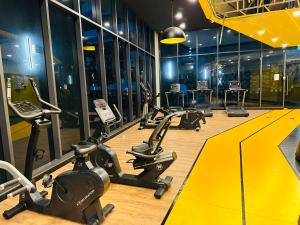 une salle de sport avec une rangée de vélos d'exercice et de tapis de course dans l'établissement Couple Suite at Neu Suites near Gleneagles, à Kuala Lumpur