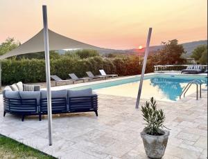 a pool with two lounge chairs and a umbrella at Mas du Murier in Correns
