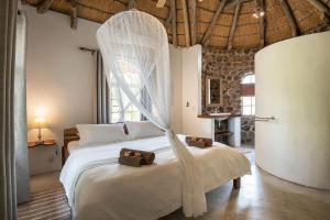 a bedroom with a bed with a mosquito net at Mobola Lodge in Mamono