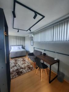 1 dormitorio con cama, escritorio y mesa en Container Guesthouse - 1 en Urubici