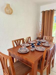 een houten tafel met borden en bekers erop bij C9 Tamarinier in Flic-en-Flac