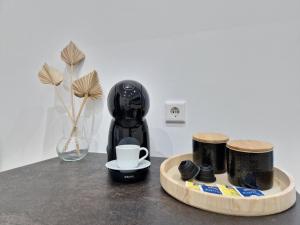 a black coffee maker sitting on a table with a coffee cup at Like Home in Solingen
