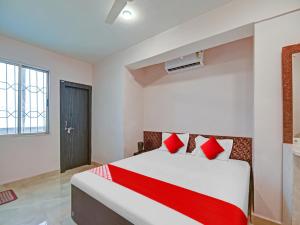 a bedroom with a white bed with red pillows at OYO Flagship Sona Residency in Rānchī
