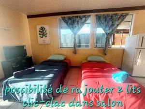 2 camas en una habitación con ventana en FARE Miti en bord de mer Fare Tepua Lodge, en Uturoa