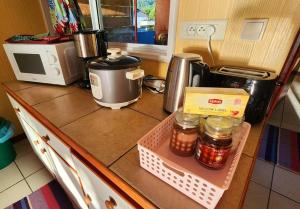 FARE Miti en bord de mer Fare Tepua Lodge في أوتوروا: طاولة مطبخ مع آلة صنع القهوة وجارات من الطعام