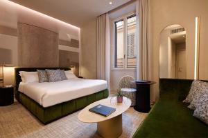 une chambre d'hôtel avec un lit et un canapé dans l'établissement Borghese Contemporary Hotel, à Rome