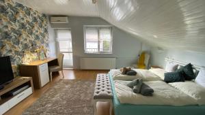 a bedroom with a bed and a desk and a television at Sweet Home Apartman in Balatonfüred
